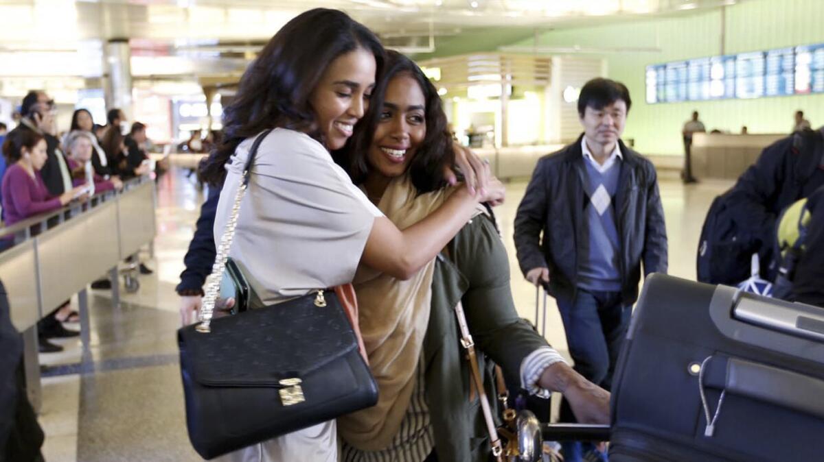 Abeer Abdelrahman, left, hugs sister Areej Ali at the Tom Bradley International Terminal at LAX after Ali's arrival from Sudan.
