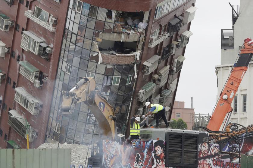 Workers begin demolition of collapsed building, two days after a powerful earthquake struck the city, in Hualien City, eastern Taiwan, Friday, April 5, 2024. (AP Photo/Chiang Ying-ying)