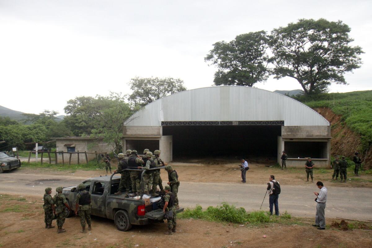 Mexican soldiers patrol the entrance to the Tlatlaya community where 22 people, alleged members of the Drug Cartel, were killed in a confrontation with soldiers of the Mexican Army. Military troops targeted by armed assailants who were guarding a warehouse returned fire June 30, 2014, killing 22 suspects.