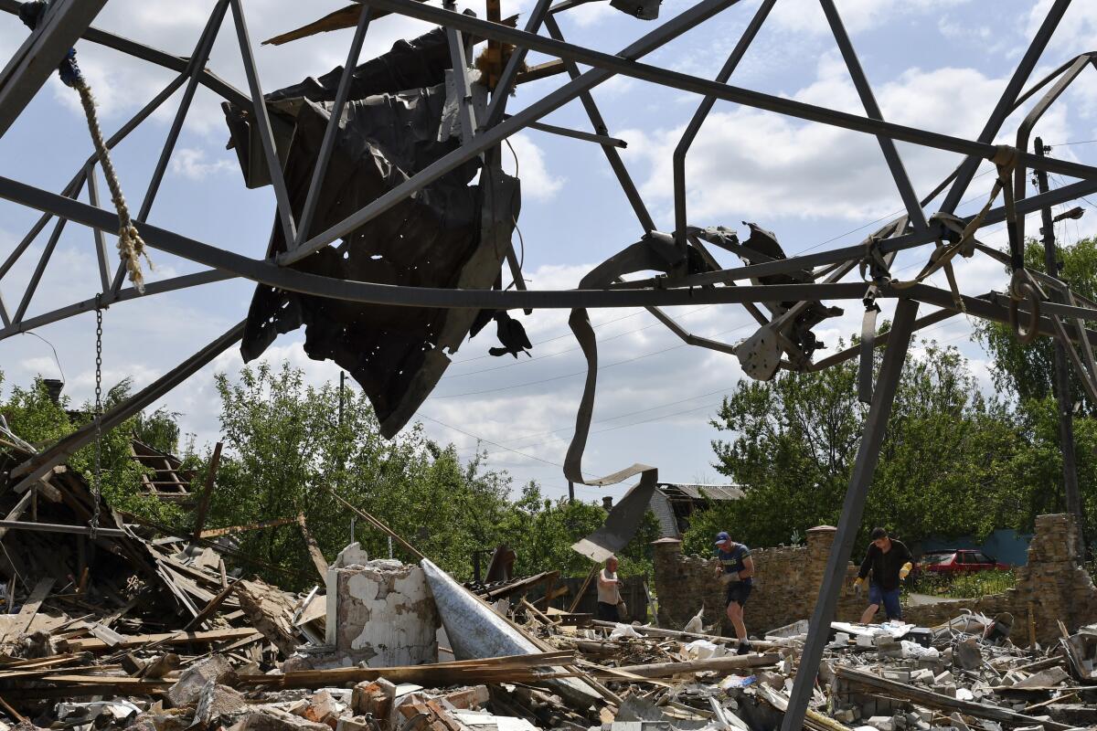 People in gloves work amid debris in the ruins of a building