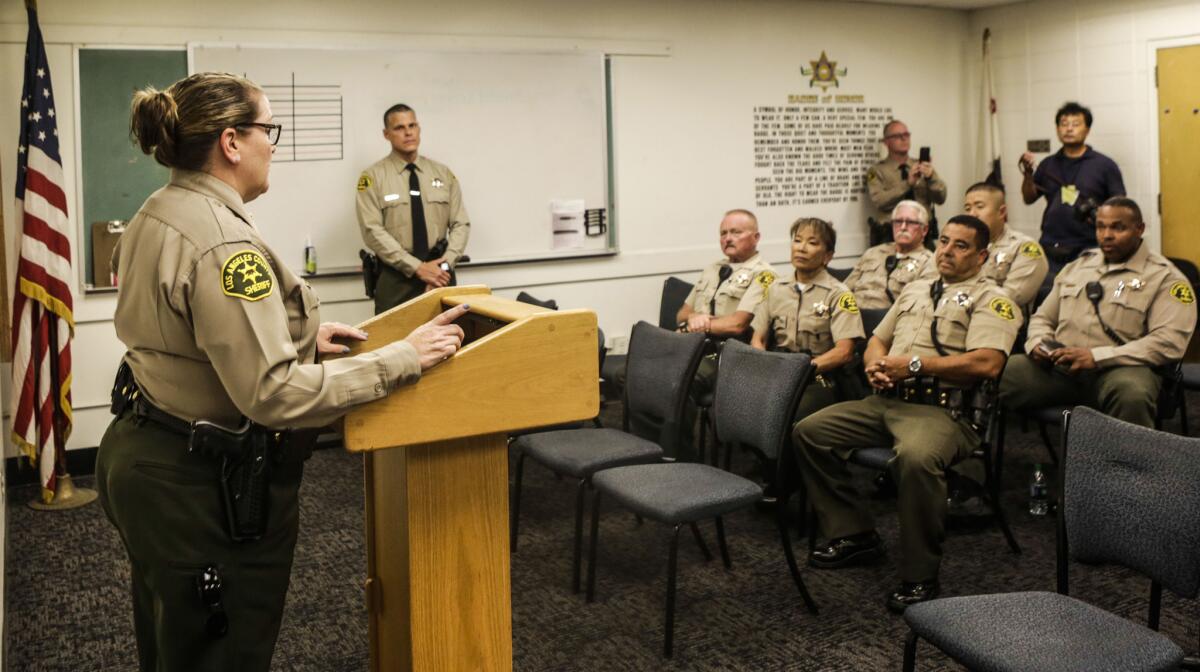 Cmdr. Coronne Jacob gives a briefing, attended by some volunteer reserve deputies, at the Los Angeles County Sheriff's Department's Industry Station.