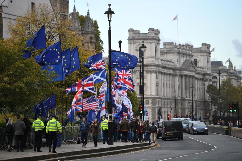 Demonstrators hold EU and Union flags as they walk near the Houses of Parliament in central London on October 29, 2019. - Britain was on course for a December election today after the main opposition Labour party said it would support Prime Minister Boris Johnson's plan, although a date has not yet been fixed. (Photo by DANIEL LEAL-OLIVAS / AFP) (Photo by DANIEL LEAL-OLIVAS/AFP via Getty Images)