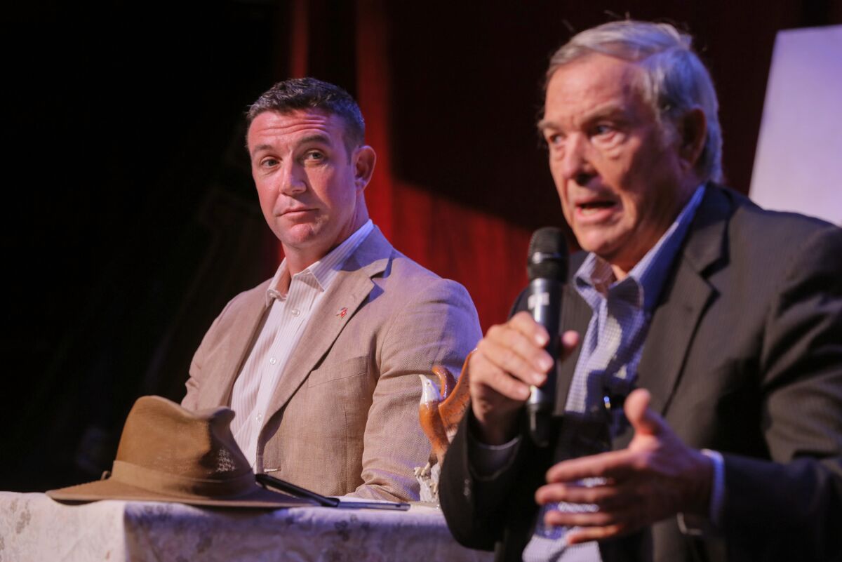 Congressman Duncan Hunter, left, listens as his father, retired Congressman Duncan Hunter speaks about border issues at their town hall meeting at the Ramona Mainstage theater.