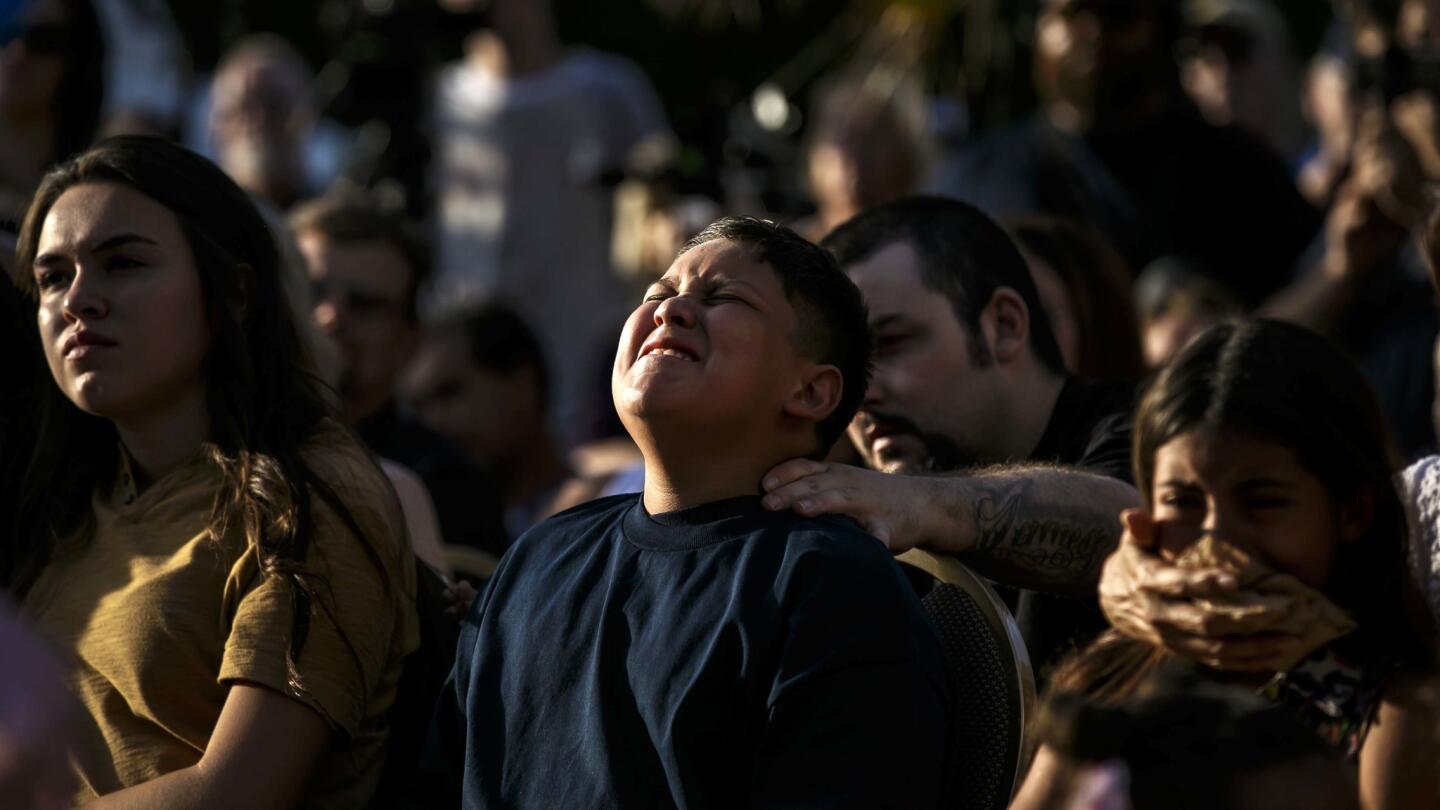 James Carter, 11, is comforted by family members during a vigil for the slain Palm Spring police officers Jose 'Gil' Vega and Lesley Zerebny.