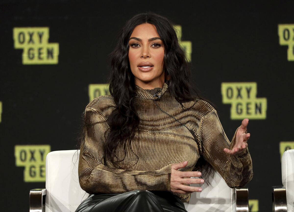 A seated woman speaks at a press tour event.