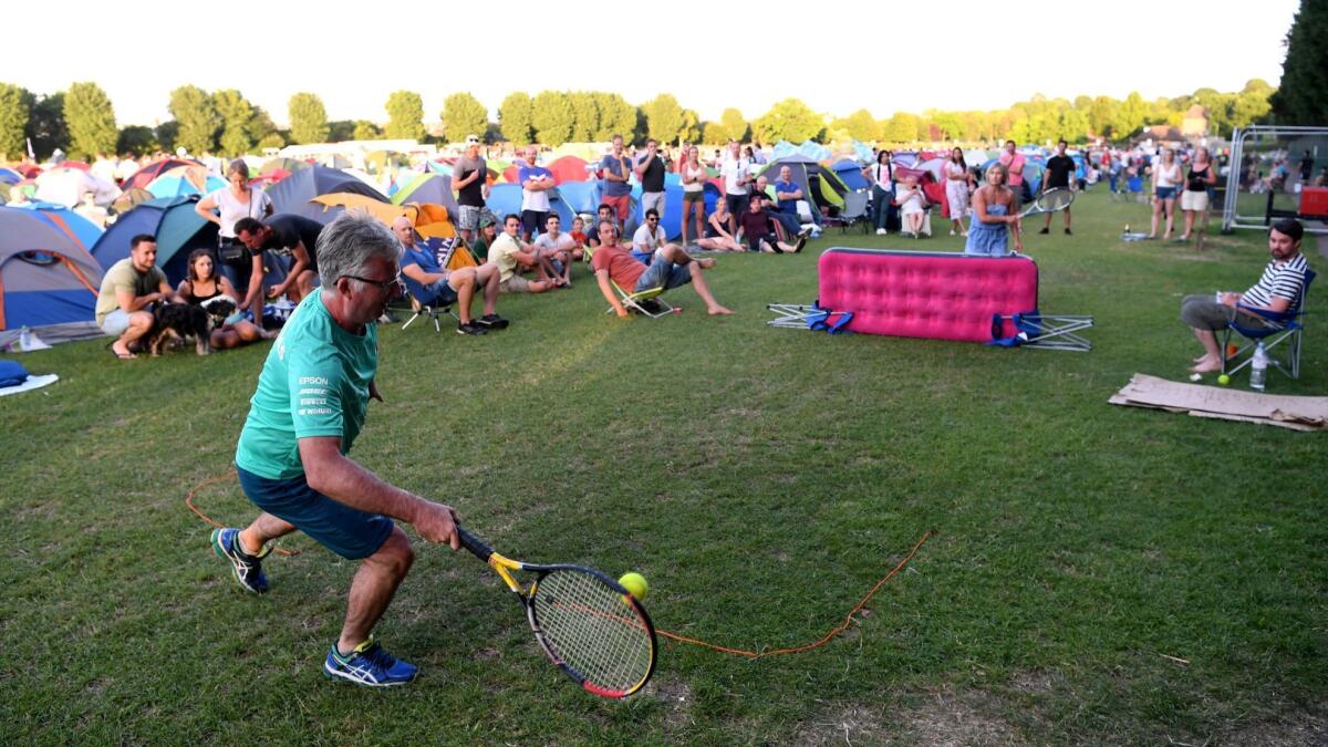Fans play tennis on a makeshift court in the Wimbledon queue campsite on Friday.