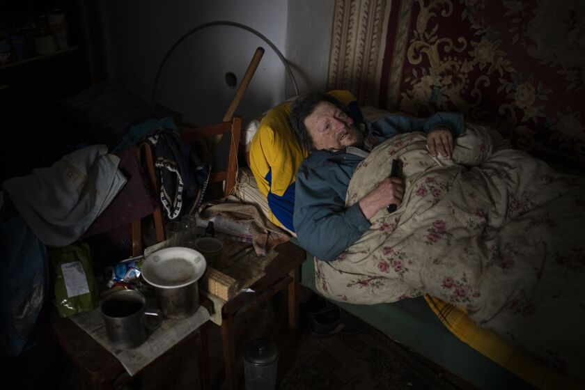 Suffering from cancer, Gennadiy Shaposhnikov, 83, rests in his partially destroyed home which was hit by Russian shelling last fall in Kalynivske, Ukraine, Saturday, Jan. 28, 2023. (AP Photo/Daniel Cole)