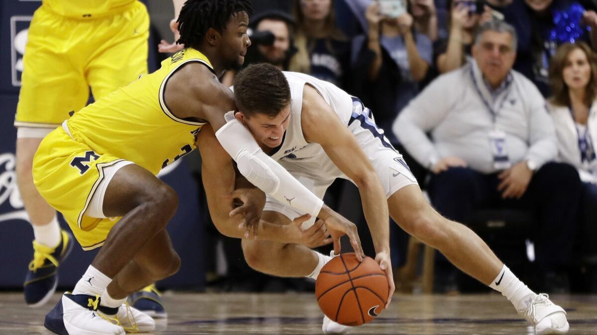 Michigan's Zavier Simpson, left, and Villanova's Collin Gillespie battle for a loose ball during the second half on Wednesday.