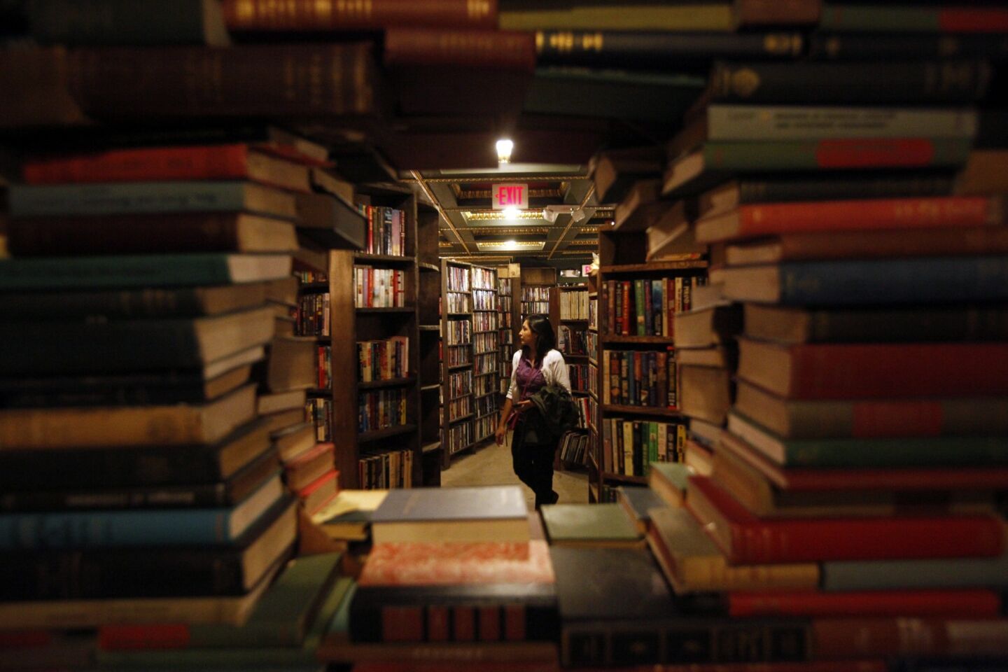A visitor is framed by a portal surrounded by books.