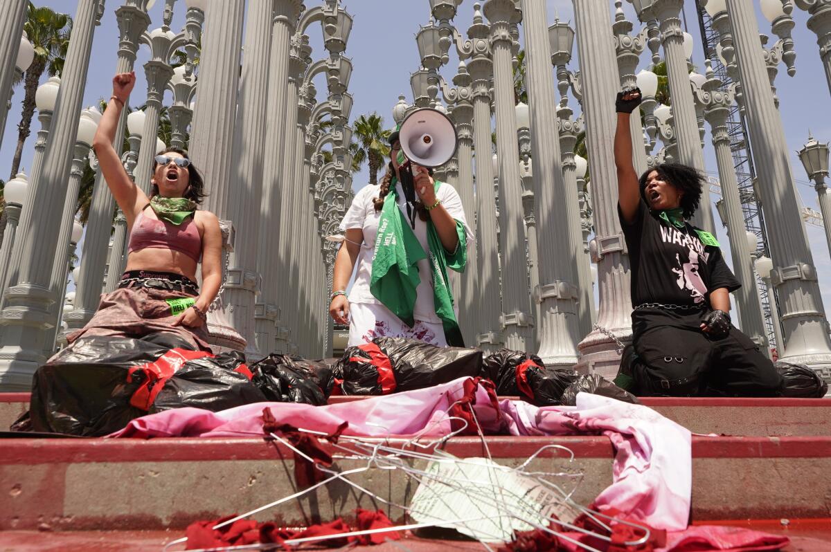 Abortion rights activists stage a "die-in" protest by chaining themselves to the lamp posts installation "Urban Light"