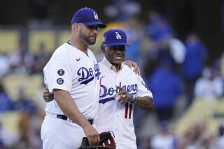 Los Angeles Dodgers' Albert Pujols walks with former Los Angeles Dodgers player Manny Mota.