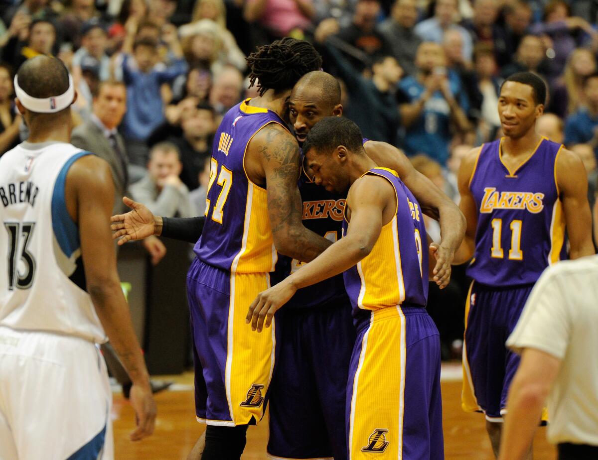 Guard Kobe Bryant is congratulated by Lakers teammates Jordan Hill and Ronnie Price after passing Michael Jordan for third place on the NBA all-time scoring list.