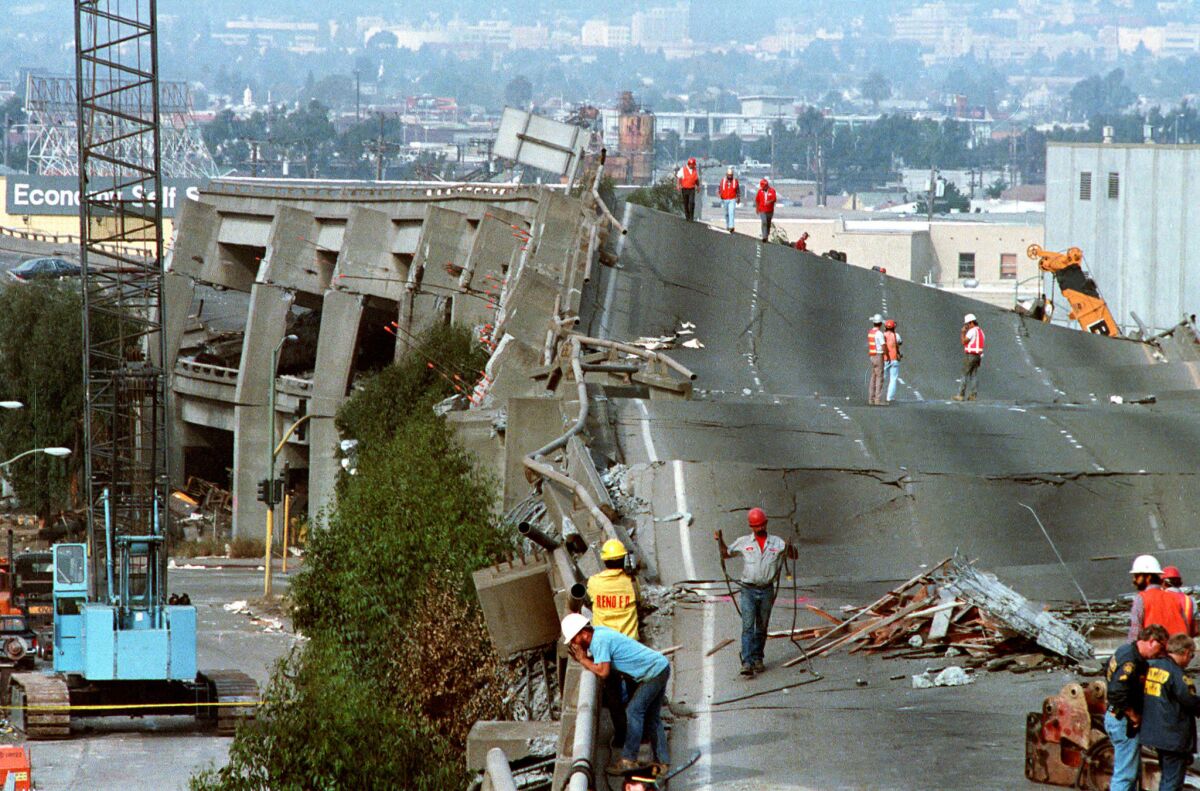 Workers check the damage to Interstate 880 in Oakland after it collapsed during the Loma Prieta earthquake in 1989. 