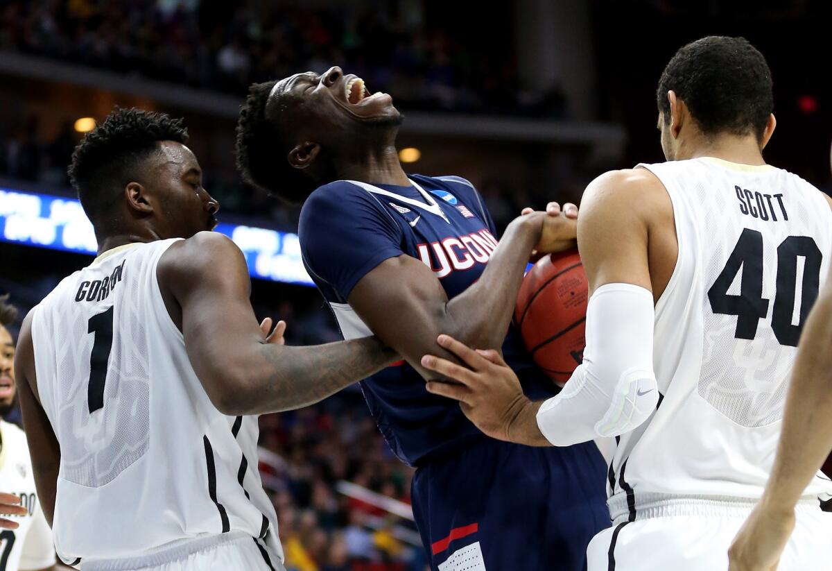 Connecticut's Amida Brimah battles for a rebound with Colorado's Wesley Gordon, left, and Josh Scott.