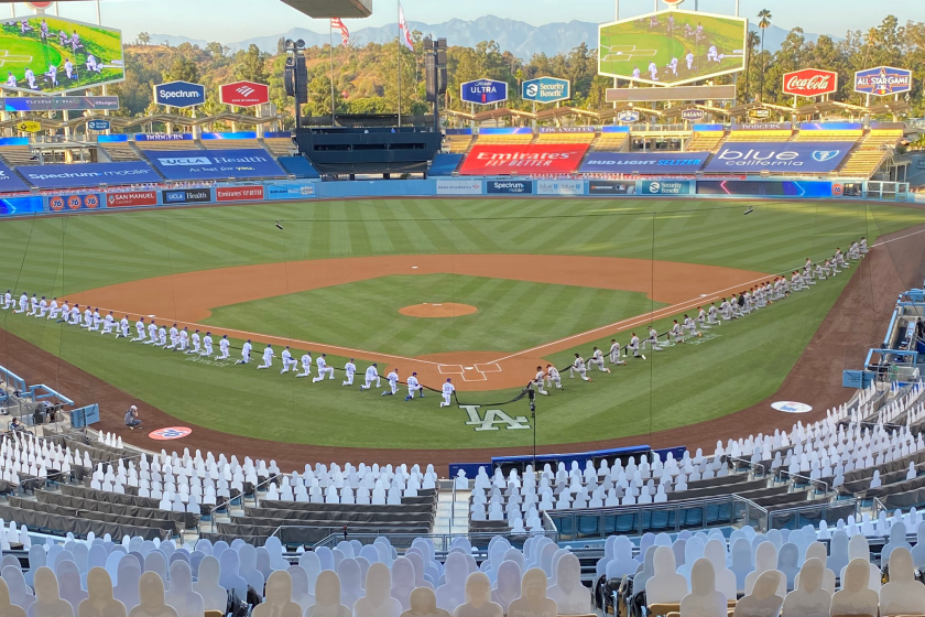 Dodgers and Giants players kneel during a moment of silence before the national anthem at the Dodgers' 2020 season opener at Dodger Stadium.
