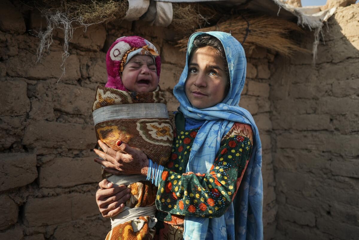 A 10-year-old girl holds her infant brother.