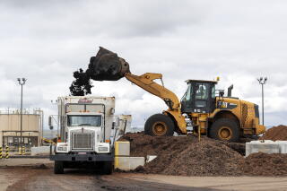 Material is loaded into a mixing truck where biosolids and amendments are combined then stored in climate controlled piles