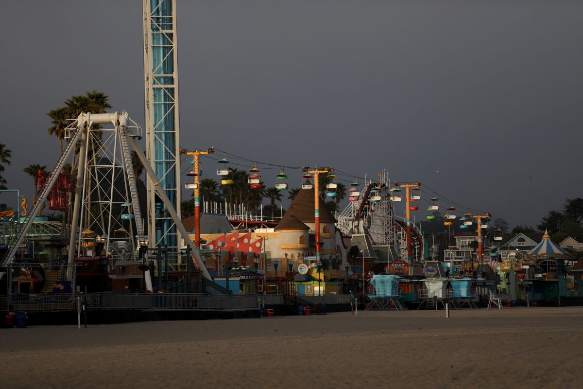 A roller coaster and other rides border the beach in Santa Cruz.
