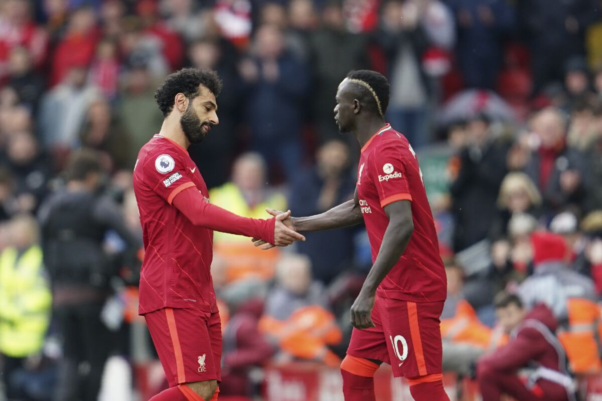 Liverpool's Mohamed Salah, left, leaves the field as his teammate Sadio Mane enters during the English Premier League soccer match between Liverpool and Watford at Anfield stadium in Liverpool, England, Saturday, April 2, 2022. (AP Photo/Jon Super)