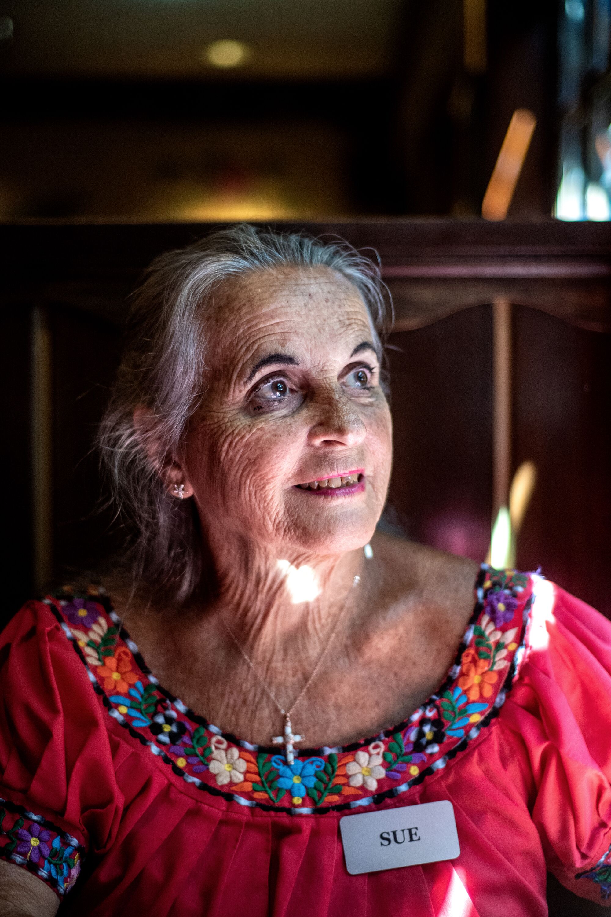 Sue Killian assise dans un stand de restaurant, regardant par la fenêtre.