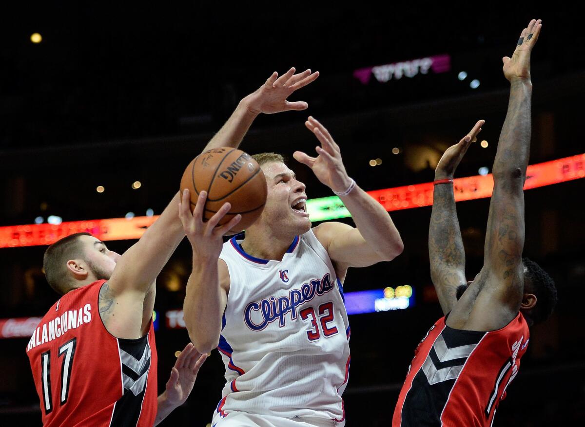 Clippers forward Blake Griffin (32) tries to score inside against Raptors big men Jonas Valanciunas (17) and Amir Johnson in the second half.