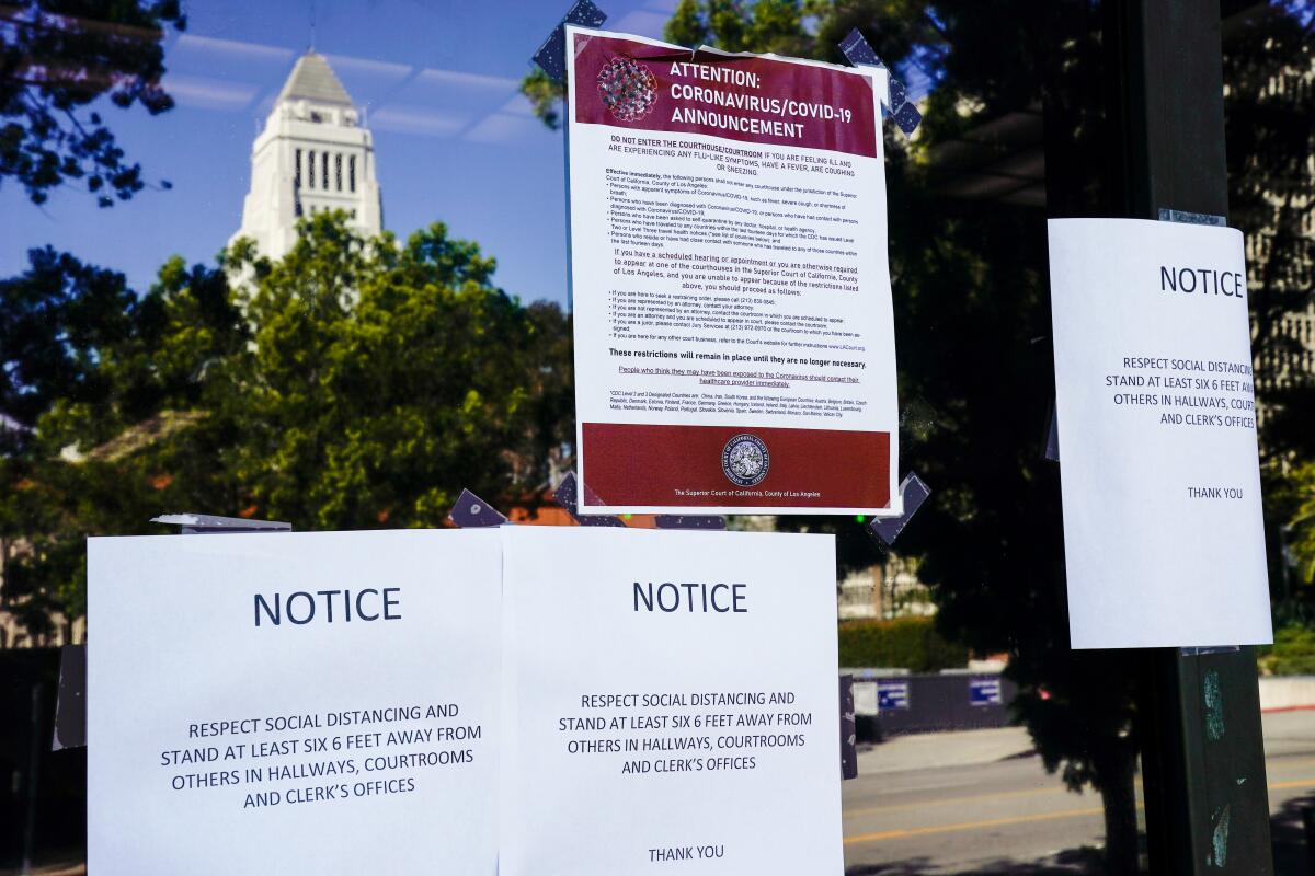 LOS ANGELES, CA - MARCH 21: Coronavirus warning signs on the Stanley Mosk Superior Courthouse in downtown Los Angeles is photographed on Saturday, March 21, 2020 in Los Angeles, CA. Earlier in the week, California Governor Gavin Newsom issued a "Safer at Home" order to the entire state to help slow the spread of the Coronavirus as it sweeps across the world. (Kent Nishimura / Los Angeles Times)