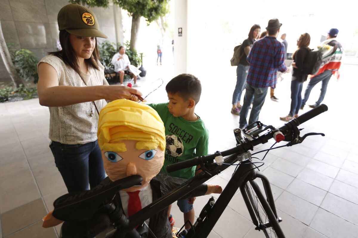 Wendy Knight, with the Service Employees International Union, Local 721, and friend Tlaloc Manteca, 7, place candy inside a piñata of President-elect Donald Trump