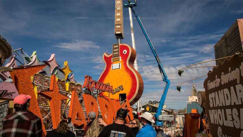Visitors watch as the neck of the Hard Rock Café guitar sign is installed at the Neon Museum.