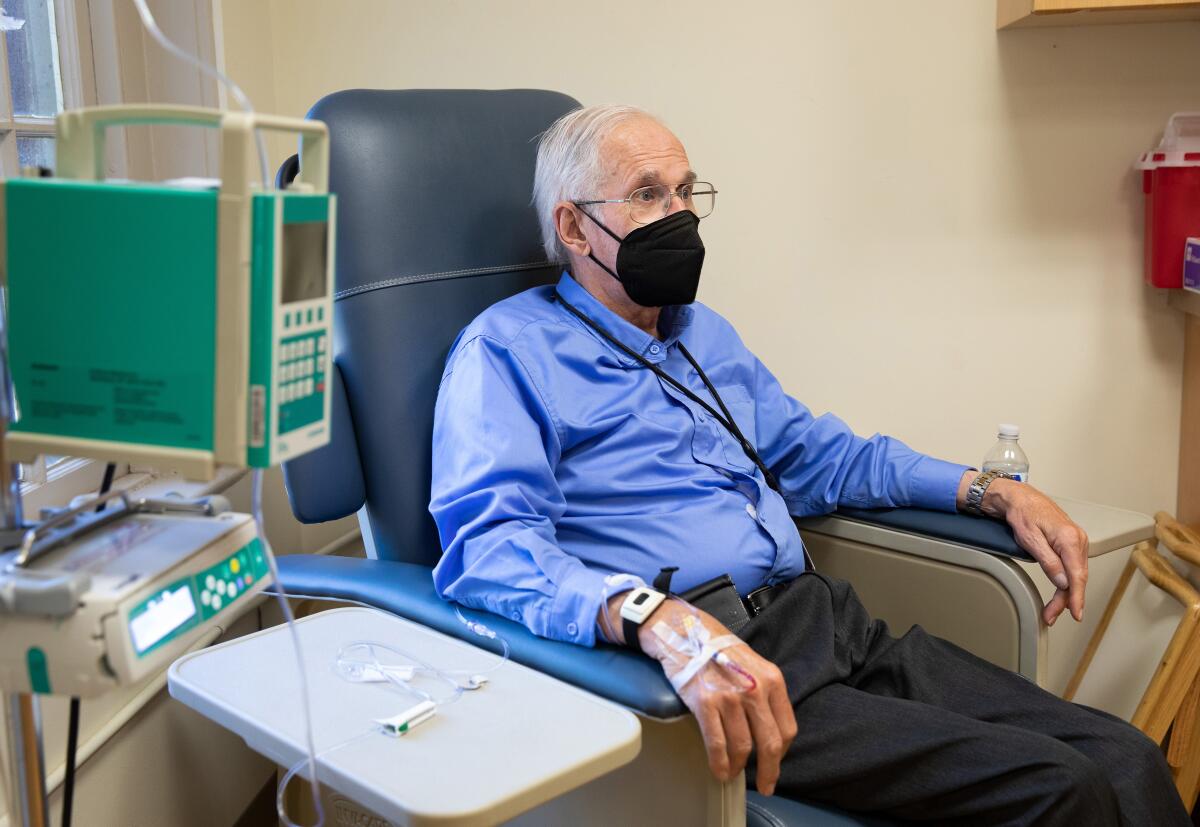 A masked patient receives an infusion.
