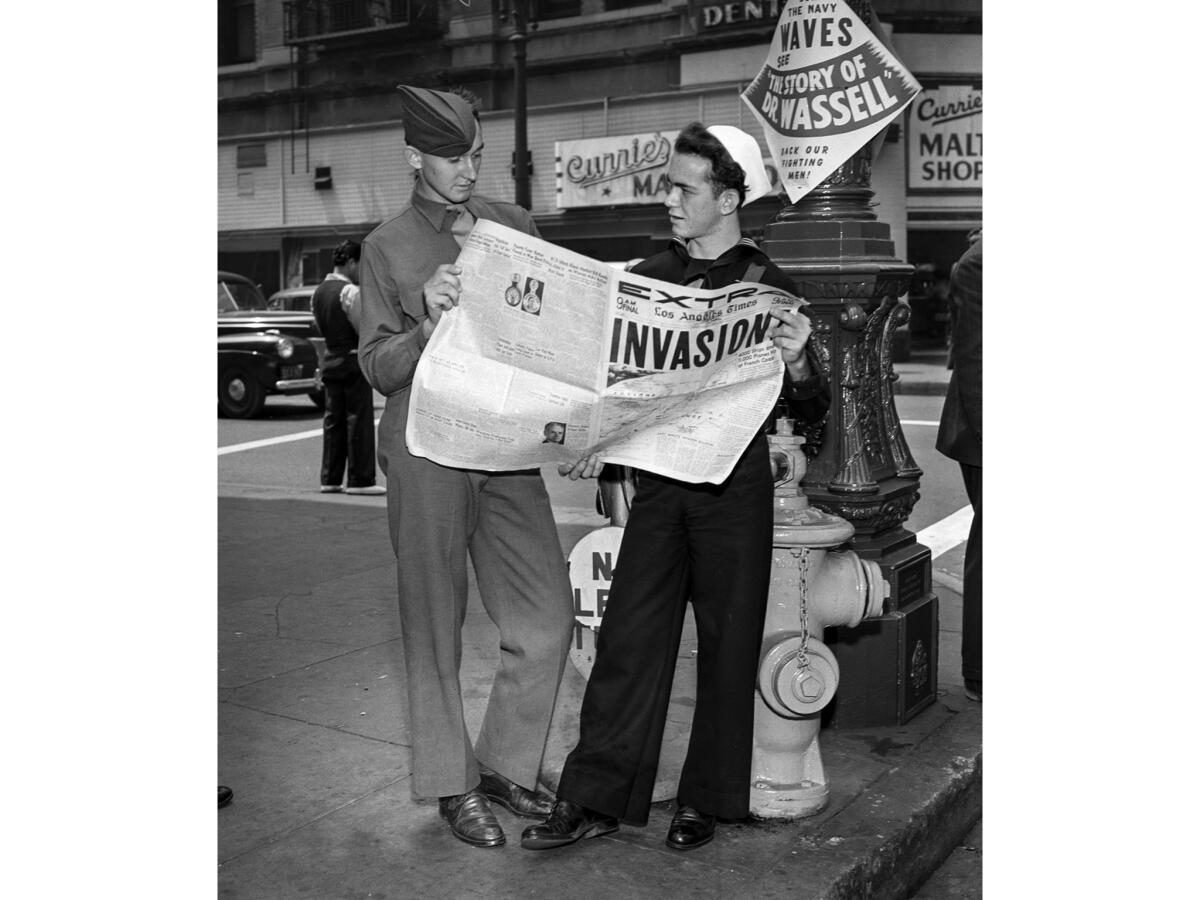 June 6, 1944: Soldier William Stettnisch and sailor John Ledet read about the D-day Invasion at 5th Street and Broadway in downtown Los Angeles.