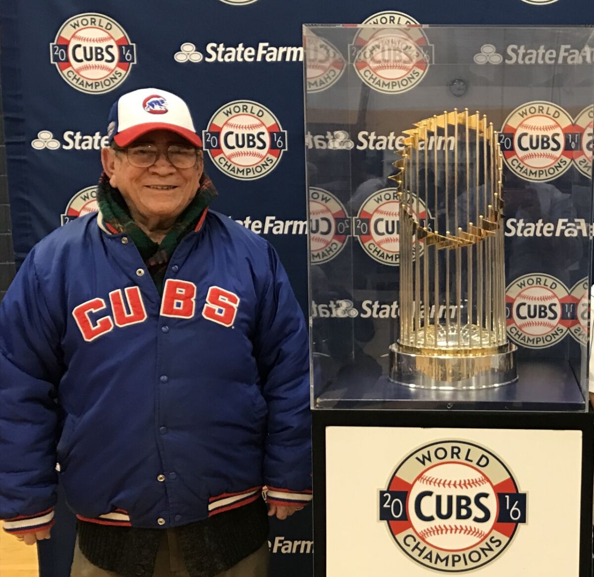 Venustiano “John” Castañeda stands next to the World Series trophy.