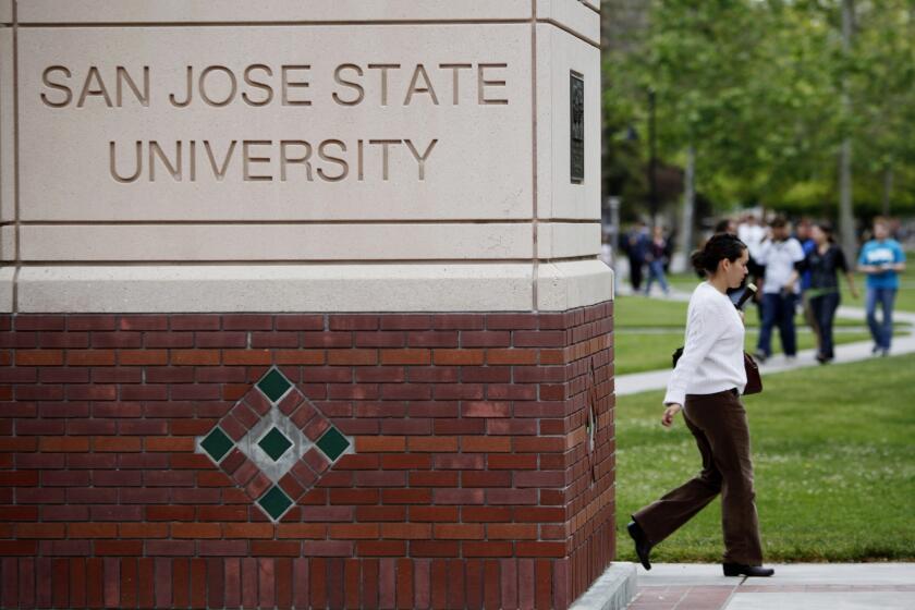 People walk on the campus of San Jose State University in San Jose, Calif.