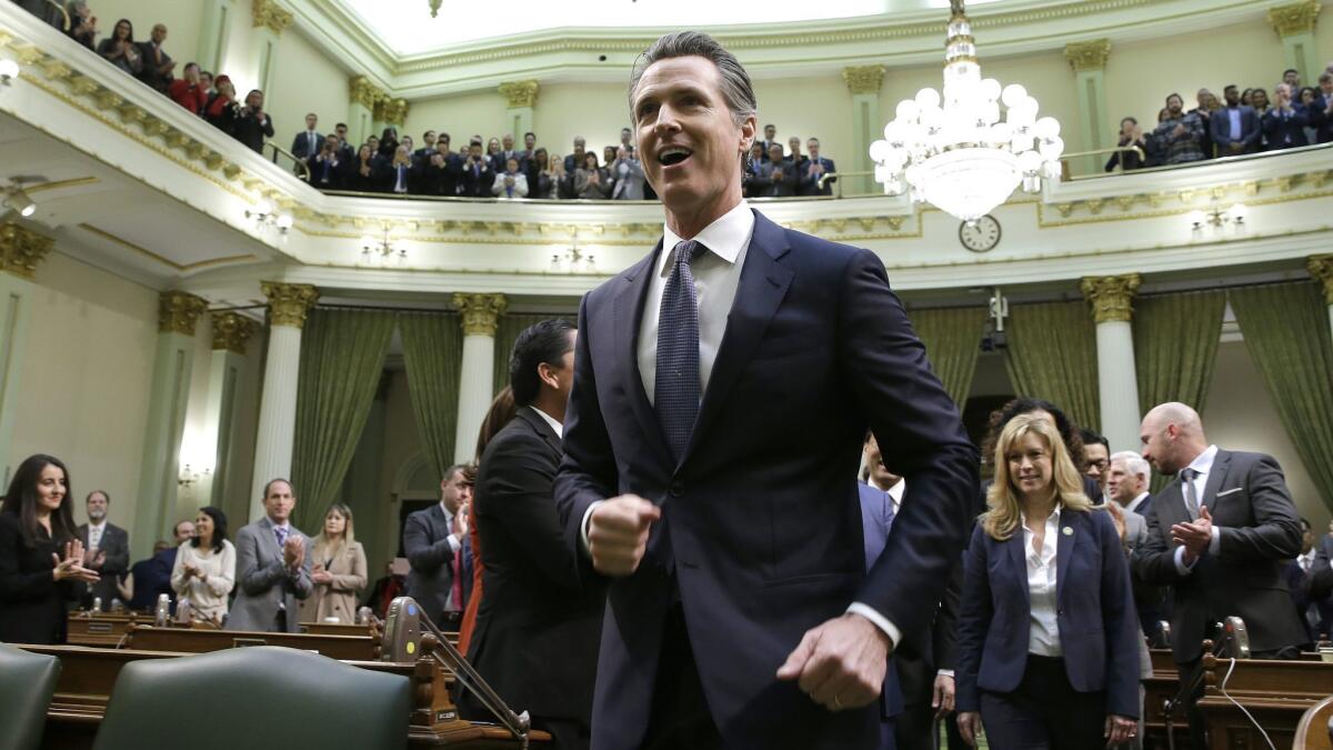 Gov. Gavin Newsom walks up the aisle of the Assembly chamber in Sacramento to deliver his State of the State address on Tuesday.