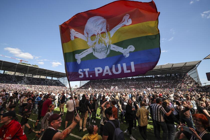 St. Pauli's fans invade the field after their team won 3-1 during a second division, Bundesliga soccer match between St. Pauli and VfL Osnabrück, at the Millerntor Stadium, in Hamburg, Germany, Sunday, May 12, 2024. (Christian Charisius/dpa via AP)