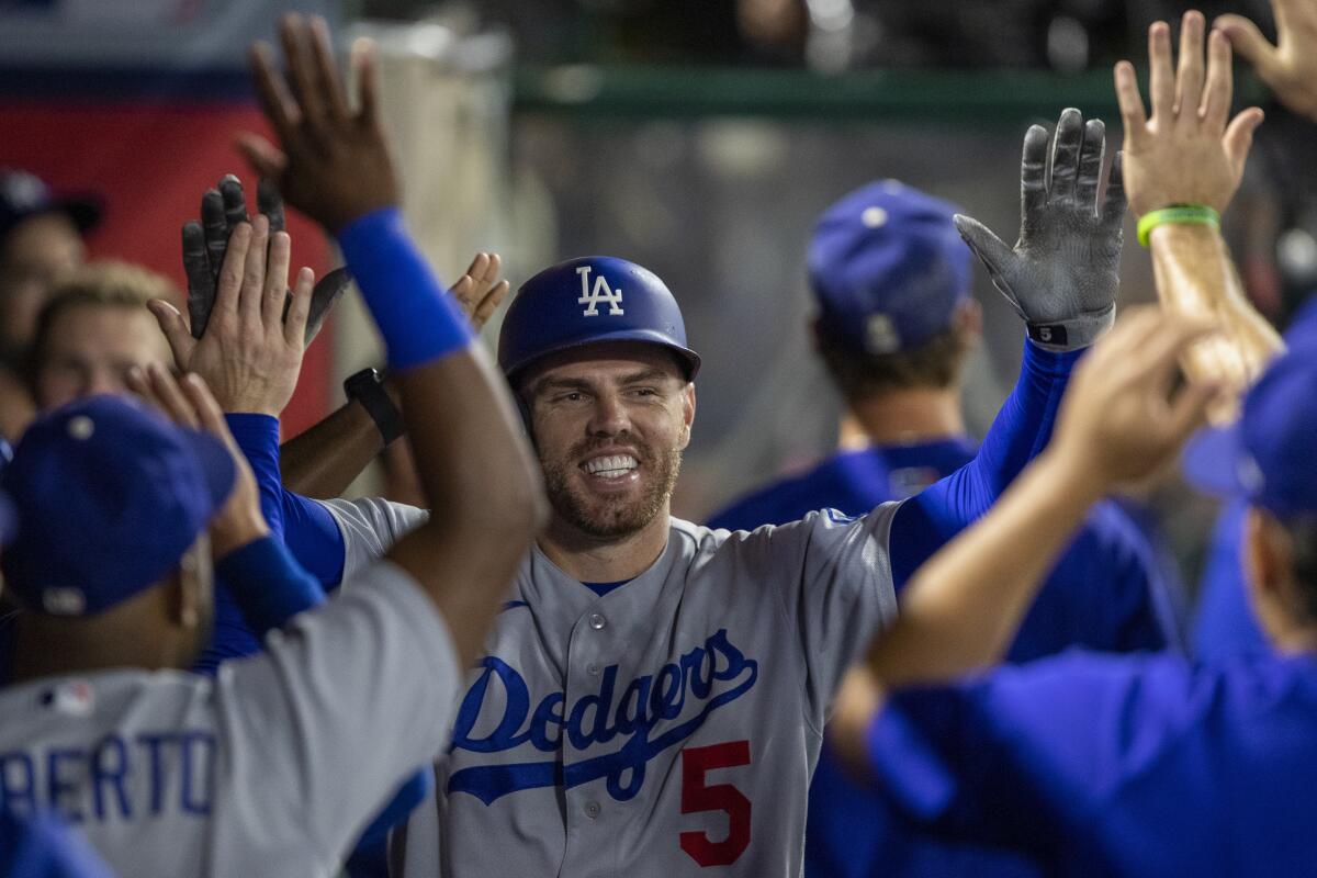 Dodgers first baseman Freddie Freeman celebrates in the dugout after hitting a solo home run.