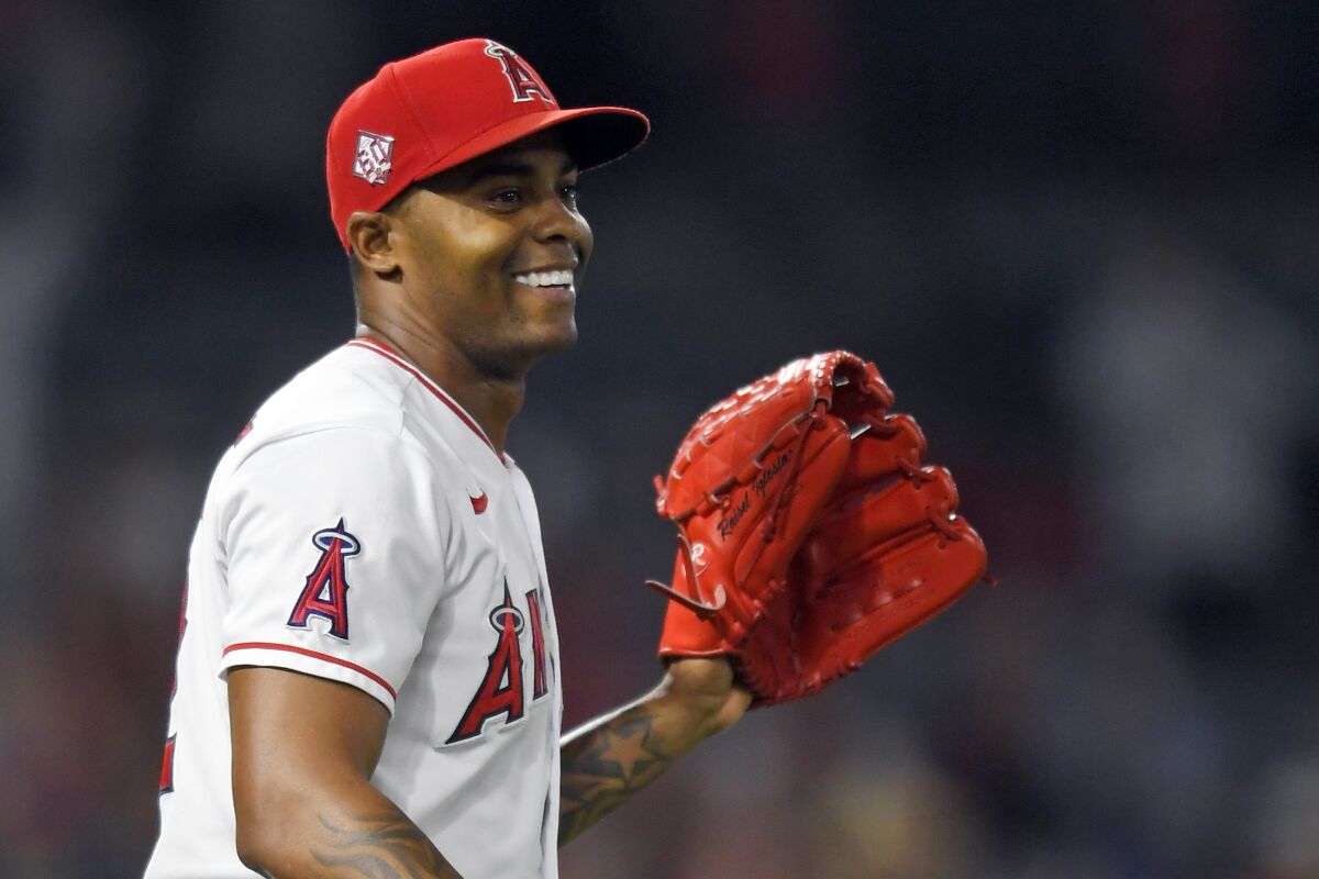 FILE - Los Angeles Angels relief pitcher Raisel Iglesias smiles after the final out in the team's 8-7 win over the Colorado Rockies in a baseball game on July 28, 2021, in Anaheim, Calif. Iglesias agreed to a four-year, $58 million deal Wednesday night, Dec. 1, 2021, to return to the Angels. (AP Photo/John McCoy, File)