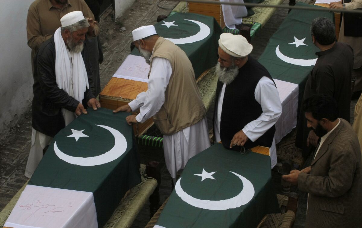 Relatives of Pakistani security officers killed in bomb blasts Saturday prepare caskets during their funeral, in Jamrud, near Peshawar.