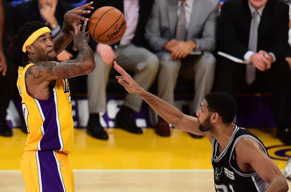 Lakers center Jordan Hill loses control of the ball against Spurs power forward Tim Duncan.