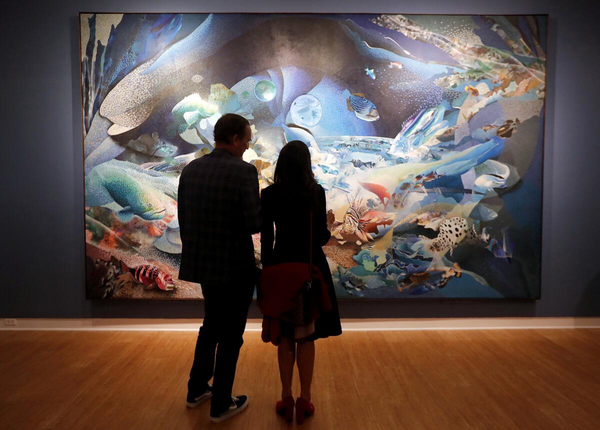 A couple pause to admire "The Big One," a 9-foot-by-15-foot painting by ocean artist Robert Young.