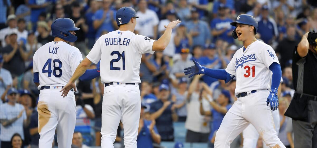 Dodgers right fielder Joc Pederson, right, is congratulated by teammates Gavin Lux, left, and Walker Buehler.