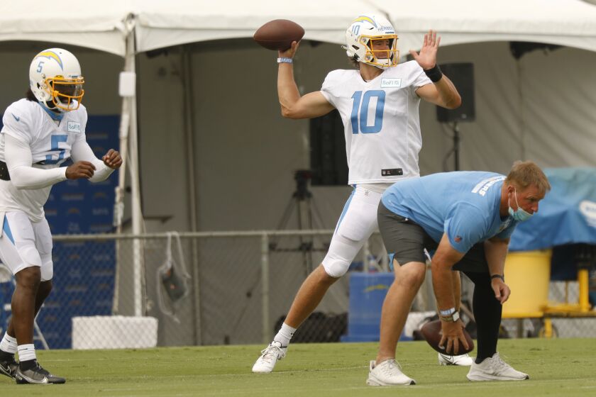 COSTA MESA, CA - AUGUST 17: Number 10 Justin Herbert, a new quarterback for the Los Angeles Chargers practices with returning quarterback number 5 Tyrod Taylor as the team conducts practice at the Hammett Sports Complex in Costa Mesa on Monday August 17, 2020 in preparation for the 2020 National Football League season. Orange County on Monday, Aug. 17, 2020 in Costa Mesa, CA. (Al Seib / Los Angeles Times
