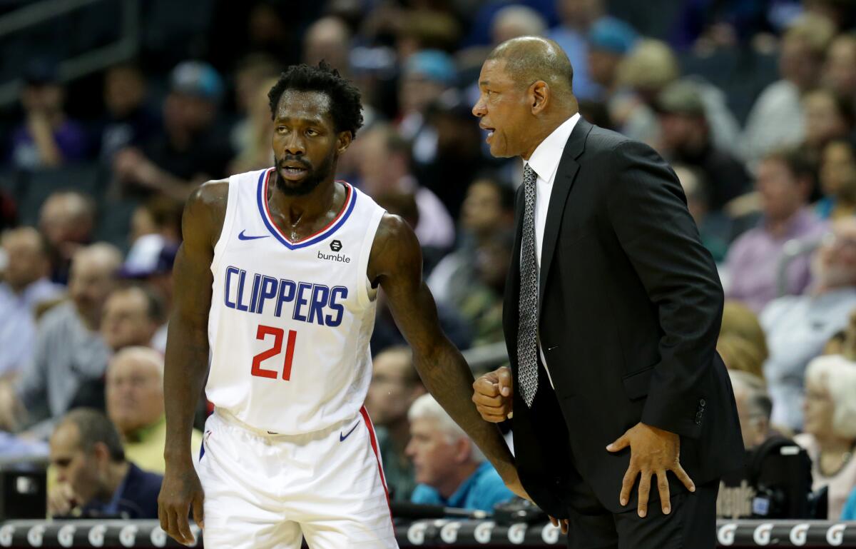 Clippers coach Doc Rivers gives some instructions to guard Patrick Beverley during a game last season.