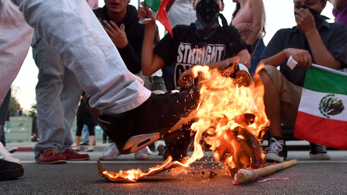 A Trump hat burns during a protest near where Republican presidential candidate Donald Trump held a rally in San Jose in June.
