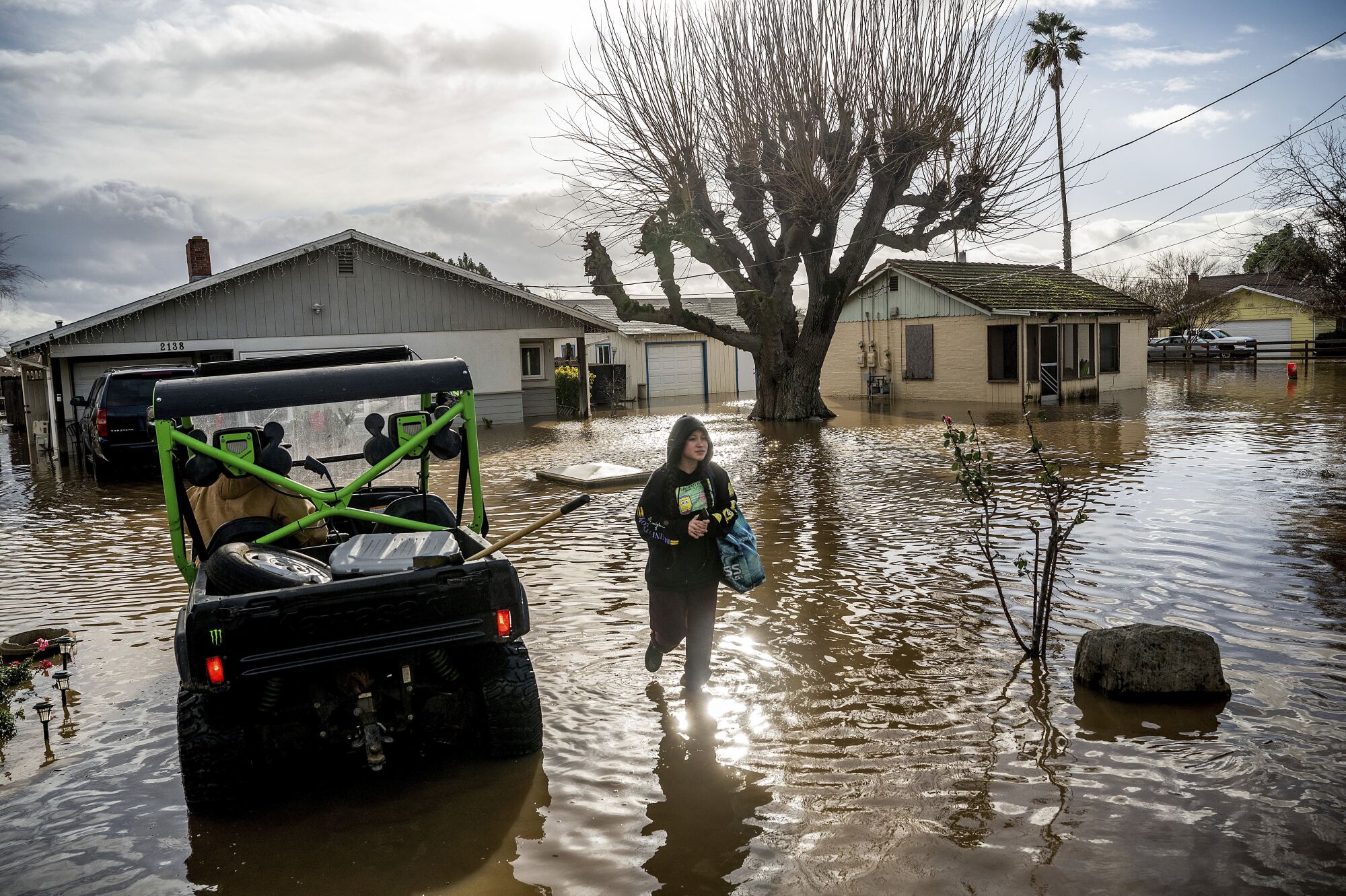 Brenda Ortega salvages items from her flooded Merced home on Tuesday.