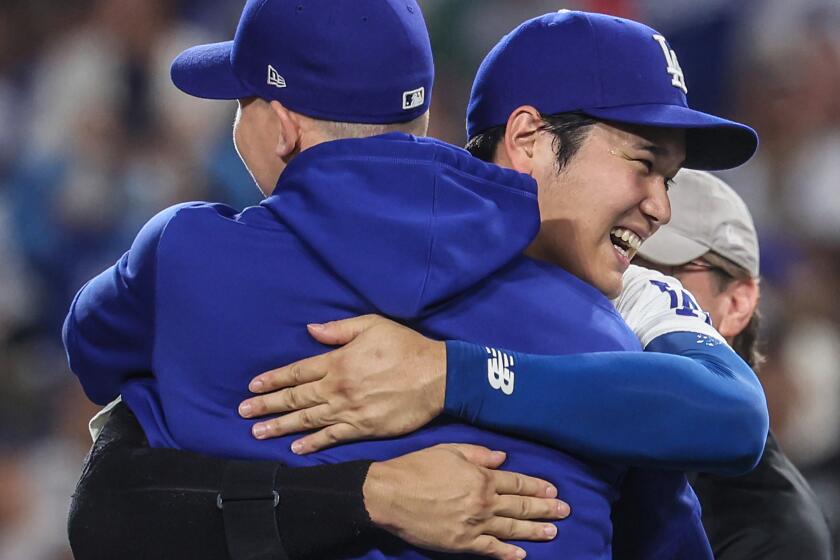 Los Angeles, CA, Thursday, September 26, 2024 - Dodgers dh Shohei Ohtani hugs teammate Walker Buehler as they celebrate clinching the NL West title at Dodger Stadium. (Robert Gauthier/Los Angeles Times)