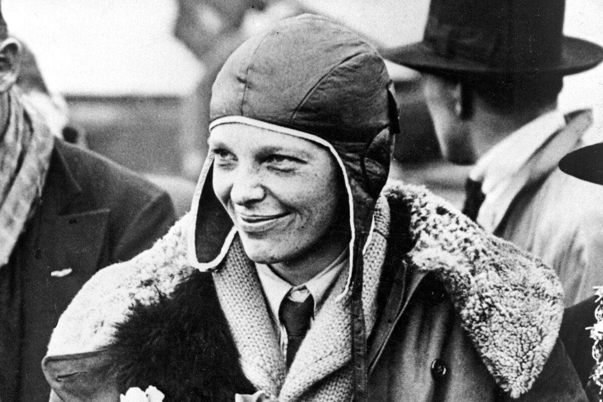 FILE - American aviatrix Amelia Earhart poses for photos as she arrives in Southampton, England, after her transatlantic flight on the "Friendship" from Burry Point, Wales, June 26, 1928. A leather helmet that Amelia Earhart wore on a flight across the Atlantic in 1928 and later lost in a crowd of fans in Cleveland, sold at auction for $825,000, Heritage Auctions said. (AP Photo/File)