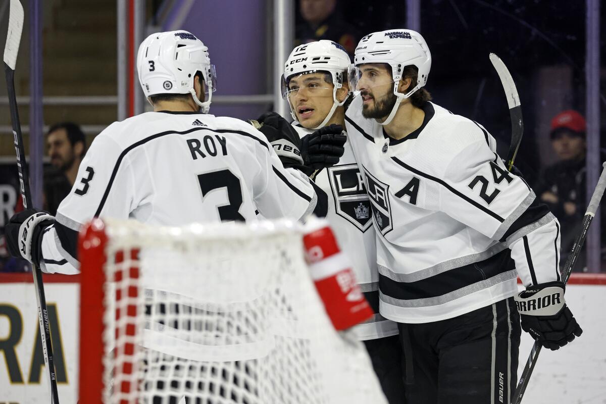 Kings forward Trevor Moore celebrates with Matt Roy and Phillip Danault after scoring against the Carolina Hurricanes.