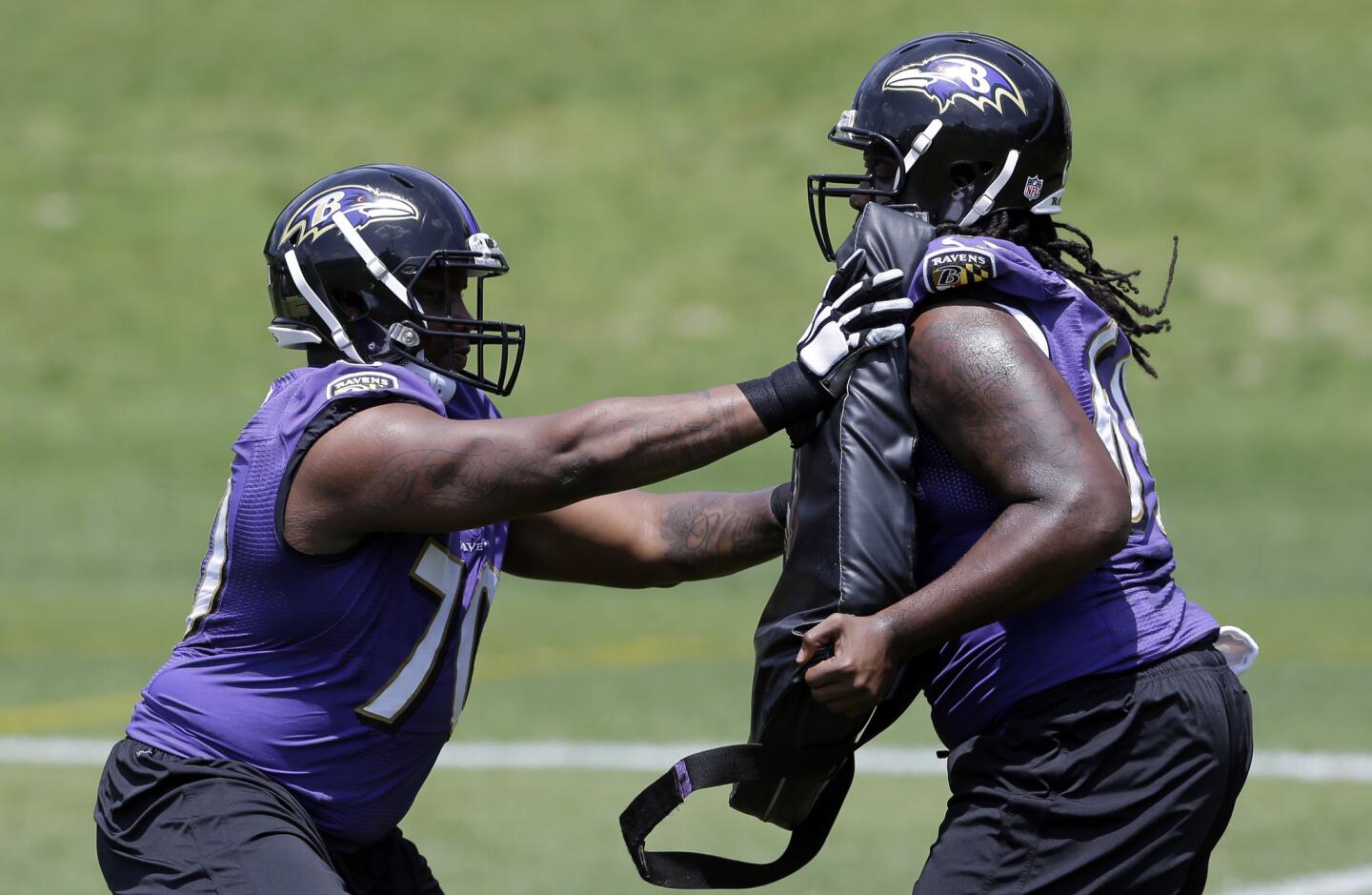 Ravens guards Robert Myers, left, and Leon Brown run a drill at an NFL football organized team activity.