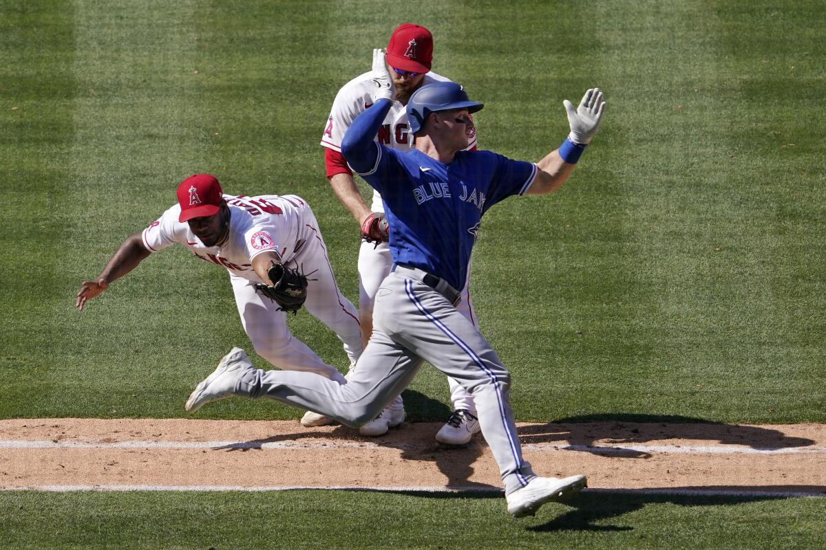 Toronto's Matt Chapman, right, avoids a tag by Angels relief pitcher Oliver Ortega.