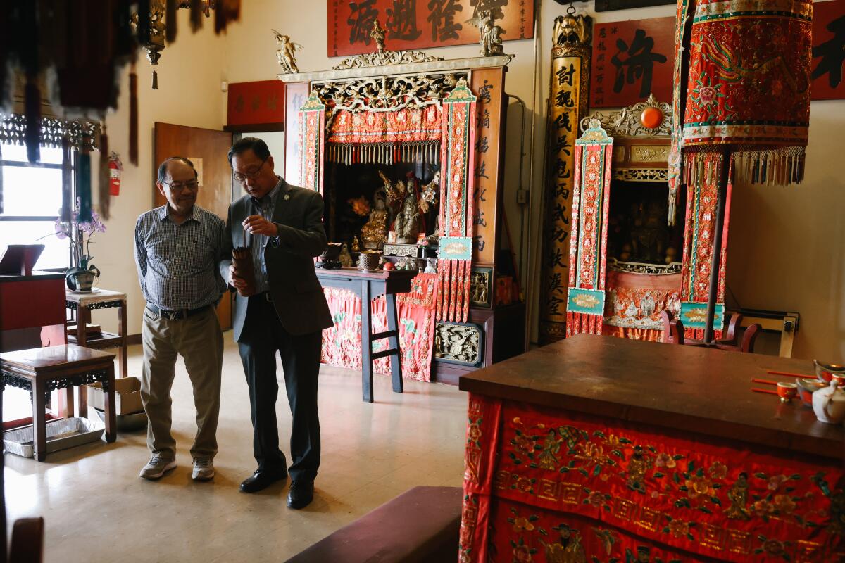 Derek Ma, left, and Thomas T. Lo   inside the temple that draws worshipers to the Kong Chow Benevolent Assn. 